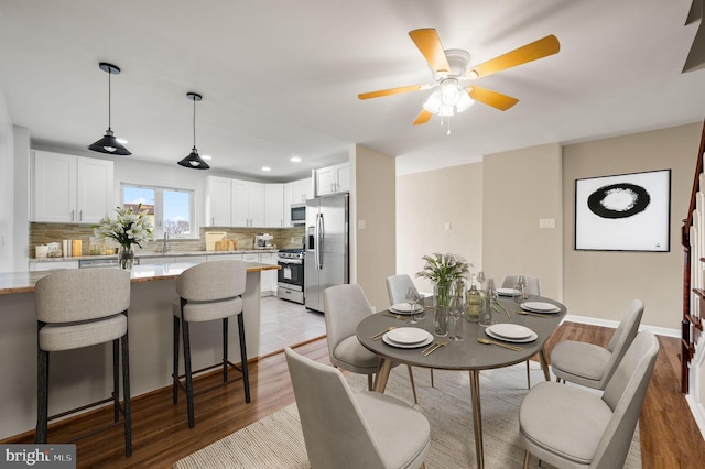 dining room with recessed lighting, light wood-type flooring, baseboards, and ceiling fan