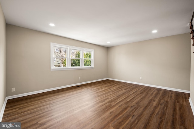 unfurnished room featuring recessed lighting, baseboards, and dark wood finished floors