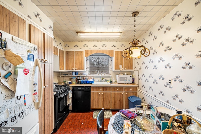 kitchen with a sink, brown cabinets, black appliances, and wallpapered walls