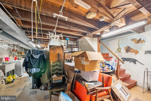 unfinished below grade area featuring independent washer and dryer and stairs