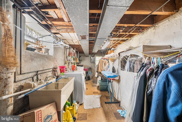 unfinished basement featuring electric panel and washing machine and dryer