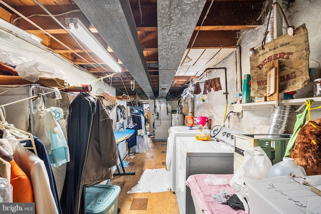 unfinished basement featuring washer and dryer, heating unit, and water heater