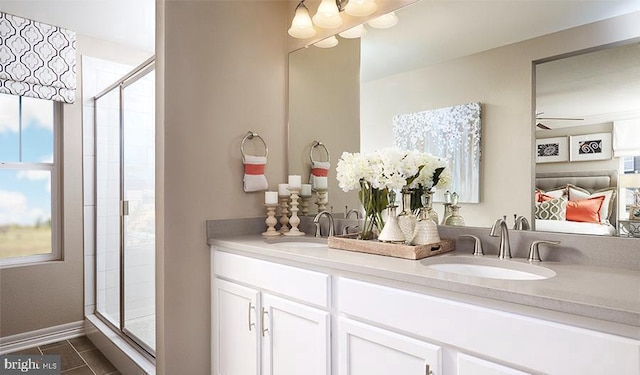 bathroom with a sink, double vanity, a shower stall, and tile patterned flooring