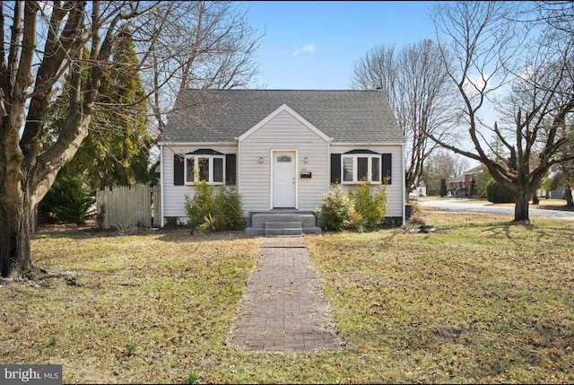 view of front of home featuring roof with shingles and fence