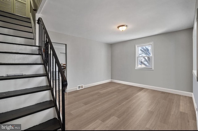 stairs featuring visible vents, baseboards, and wood finished floors