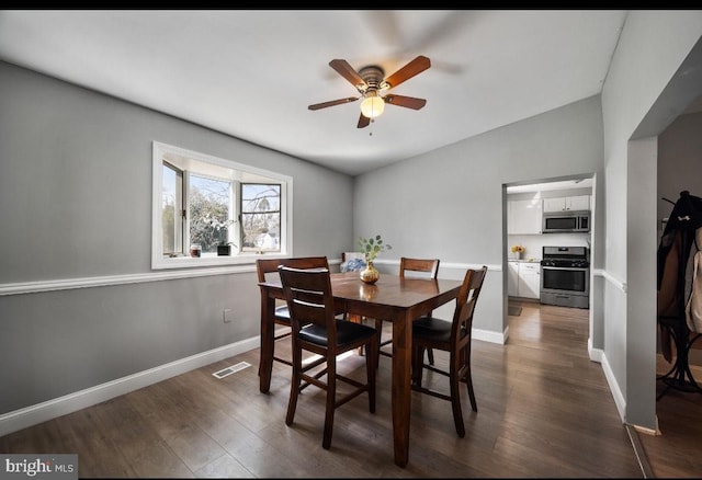 dining space featuring dark wood-style floors, visible vents, baseboards, and a ceiling fan