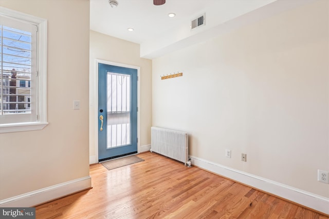 foyer featuring visible vents, radiator, baseboards, recessed lighting, and wood finished floors