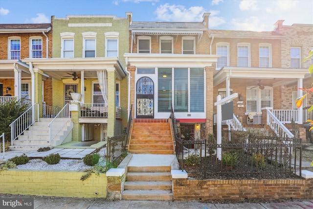 multi unit property featuring brick siding, ceiling fan, and stairs