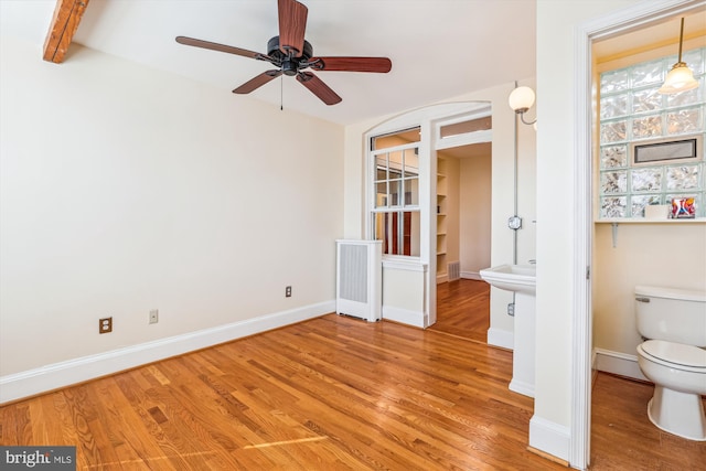 interior space with light wood finished floors, visible vents, radiator, and baseboards