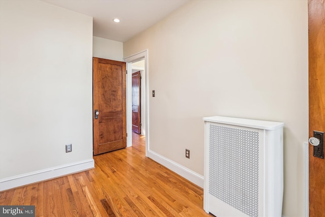 empty room with recessed lighting, light wood-style floors, and baseboards