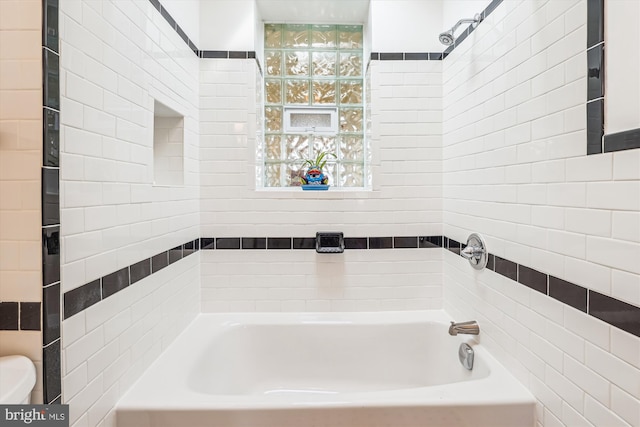 full bath featuring toilet, a tub, and a shower