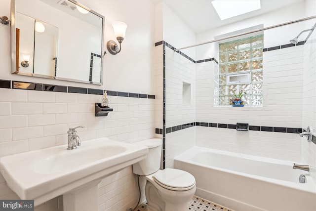 full bath featuring visible vents,  shower combination, a sink, tile walls, and toilet