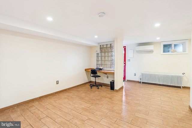 office area featuring light wood-type flooring, a wall mounted AC, built in desk, radiator heating unit, and baseboards