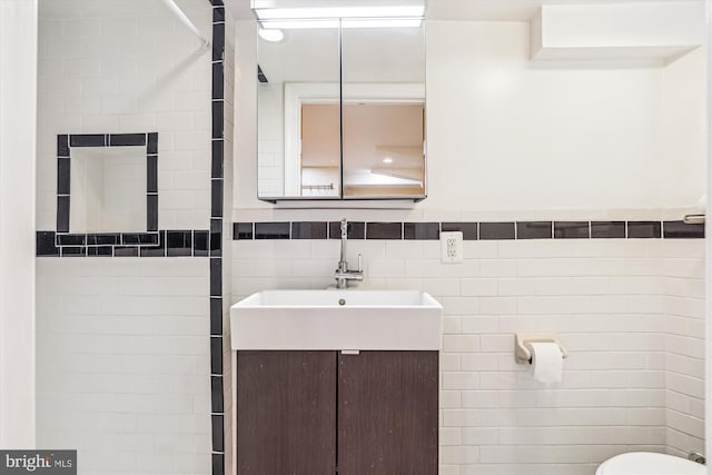 half bath featuring toilet, tile walls, and vanity