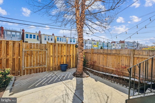 view of patio featuring fence and a gate