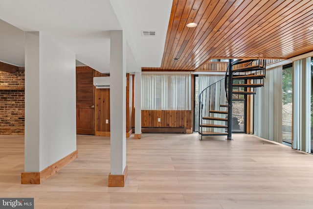 interior space featuring visible vents, a baseboard radiator, stairs, wood finished floors, and a wall unit AC