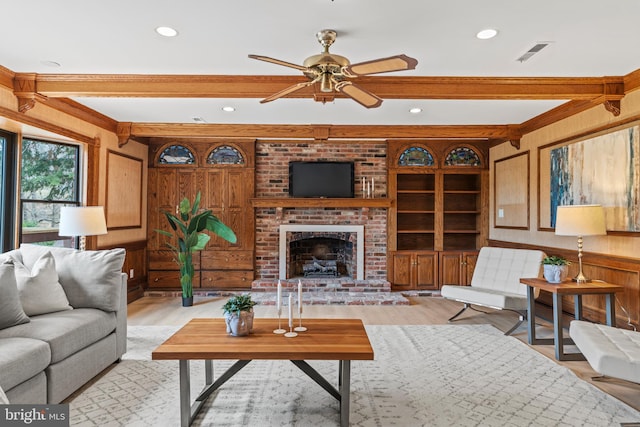 living room with visible vents, wooden walls, light wood-style floors, and beamed ceiling
