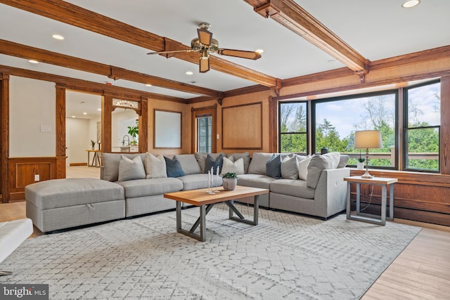 living room featuring wooden walls, recessed lighting, a ceiling fan, beam ceiling, and light wood-type flooring
