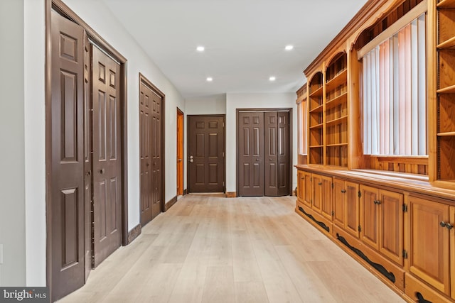 hallway with baseboards, light wood-type flooring, and recessed lighting