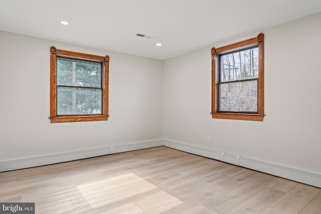 spare room with plenty of natural light, visible vents, wood finished floors, and recessed lighting