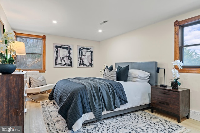 bedroom with light wood finished floors, visible vents, and recessed lighting