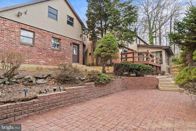 back of property featuring brick siding and a patio area
