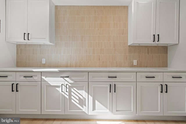 kitchen with white cabinetry, light countertops, and decorative backsplash