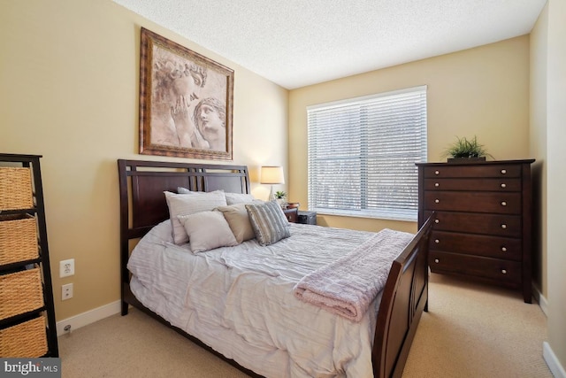 bedroom featuring light carpet, a textured ceiling, and baseboards