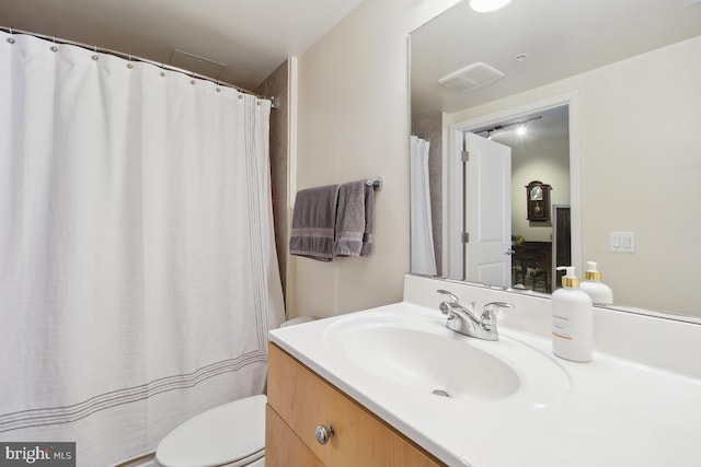 bathroom with vanity, toilet, and visible vents