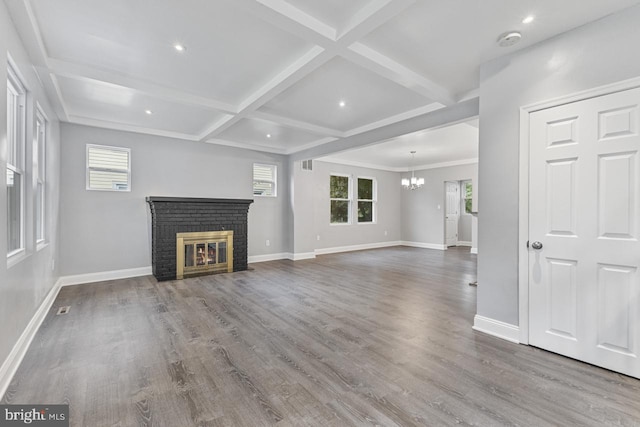 unfurnished living room with a brick fireplace, baseboards, and wood finished floors