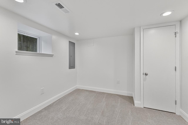 carpeted empty room featuring electric panel, visible vents, baseboards, and recessed lighting