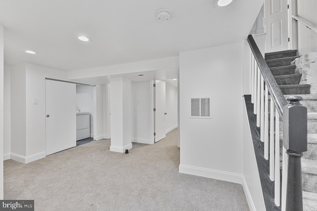 finished basement with visible vents, washer / dryer, recessed lighting, stairs, and light carpet