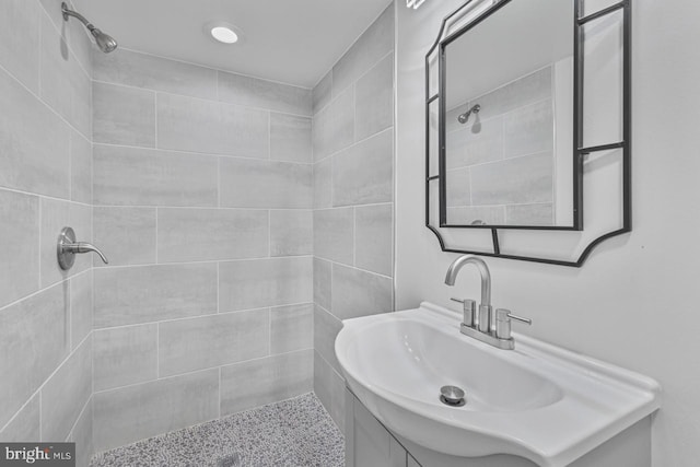 full bathroom featuring vanity and a tile shower