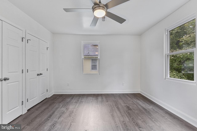 unfurnished bedroom with a ceiling fan, baseboards, and wood finished floors