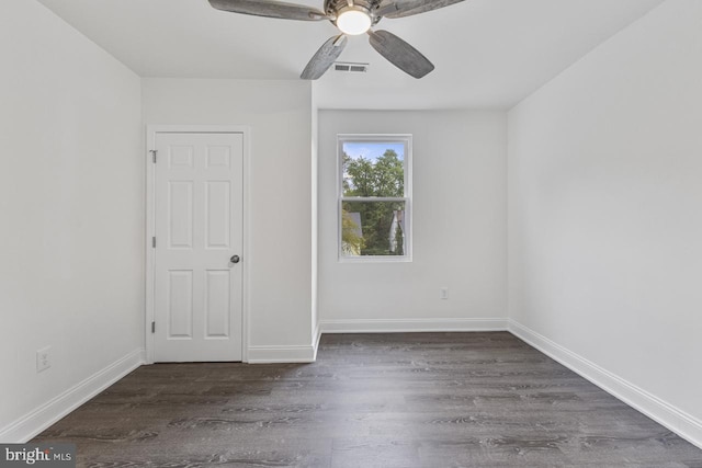 spare room featuring visible vents, wood finished floors, baseboards, and ceiling fan