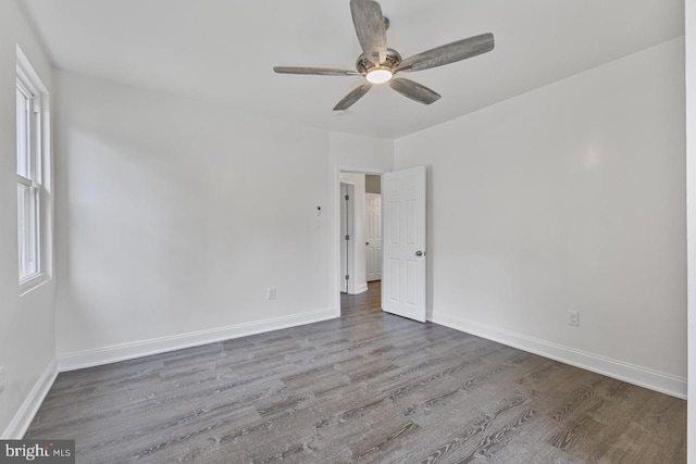 empty room featuring ceiling fan, baseboards, and wood finished floors