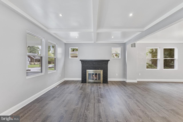 unfurnished living room featuring visible vents, beamed ceiling, a brick fireplace, and baseboards