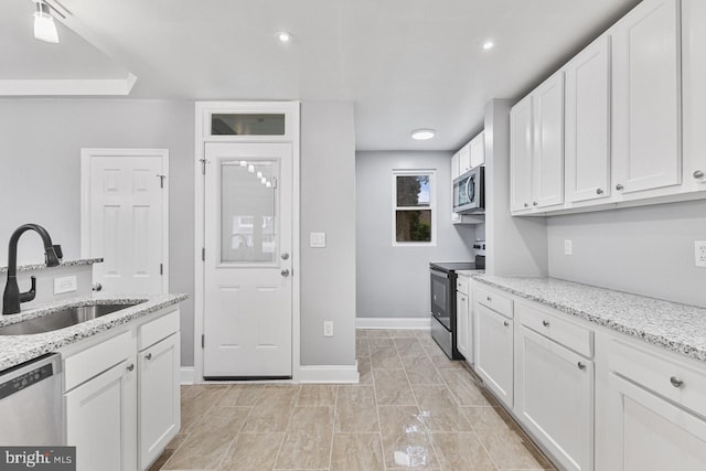 kitchen with white cabinetry, stainless steel appliances, and a sink