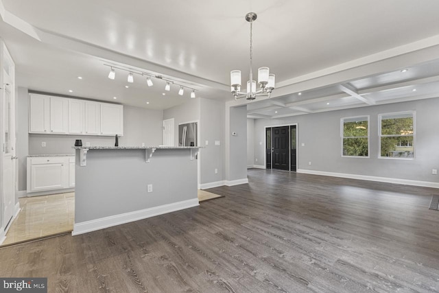 kitchen with wood finished floors, baseboards, white cabinets, stainless steel refrigerator with ice dispenser, and open floor plan