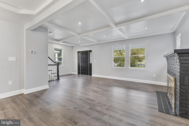 unfurnished living room featuring stairway, baseboards, a brick fireplace, and wood finished floors