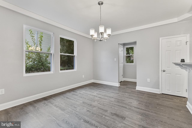 unfurnished room with an inviting chandelier, dark wood-type flooring, and baseboards