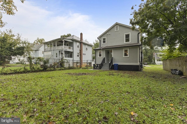 back of house featuring central AC unit, a lawn, entry steps, and fence