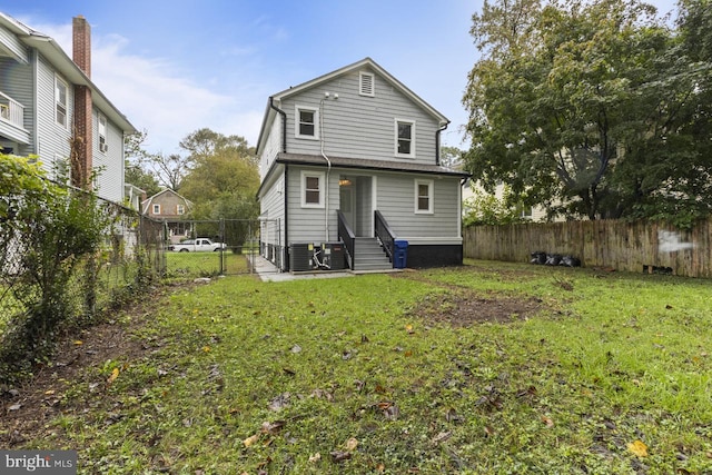 rear view of house featuring a gate, central AC unit, a yard, a fenced backyard, and entry steps