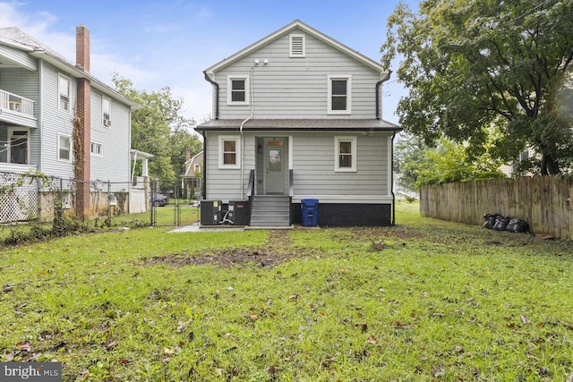 rear view of property with a gate, a lawn, entry steps, and fence