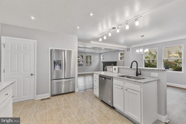 kitchen with visible vents, a kitchen island with sink, a sink, appliances with stainless steel finishes, and white cabinetry