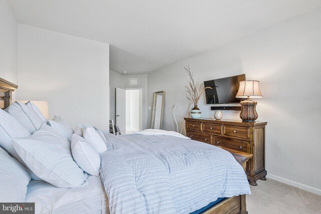 bedroom with light carpet, visible vents, and baseboards