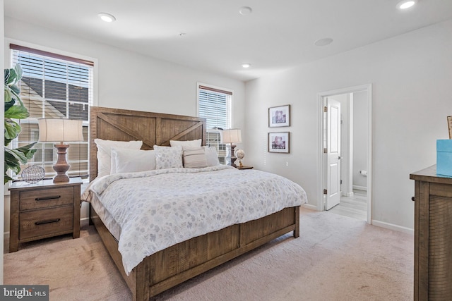 bedroom featuring light carpet, recessed lighting, ensuite bathroom, and baseboards