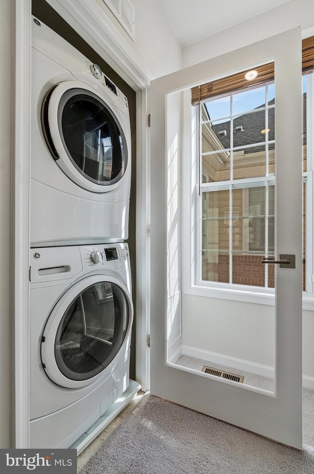 washroom featuring laundry area and stacked washing maching and dryer