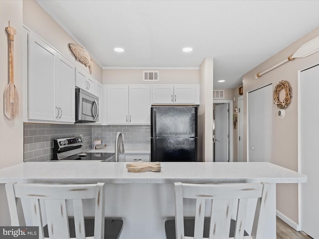 kitchen featuring a peninsula, stainless steel appliances, and light stone counters