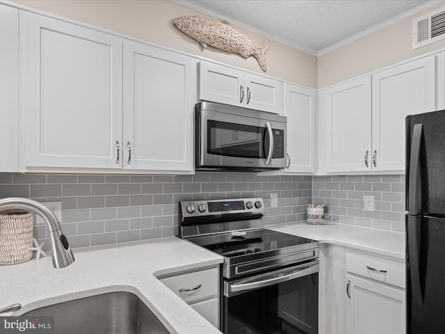 kitchen featuring visible vents, ornamental molding, stainless steel appliances, tasteful backsplash, and a sink